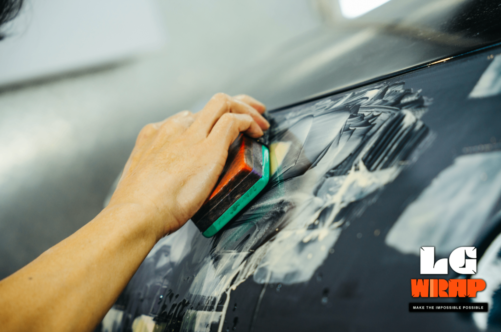Close-up of body filler application with a spreader on the Mazda MX-5 NA's front end