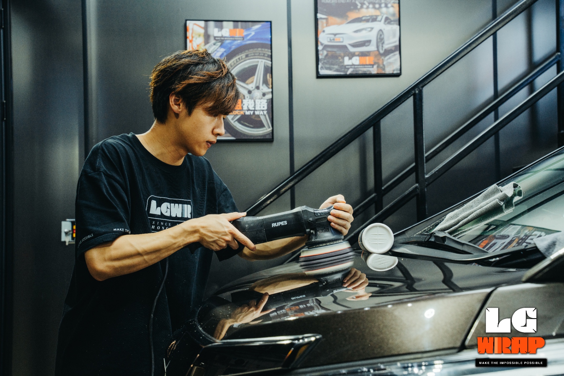 Letsgetwrap technician using RUPES dual-action polisher for paint correction on dark paint