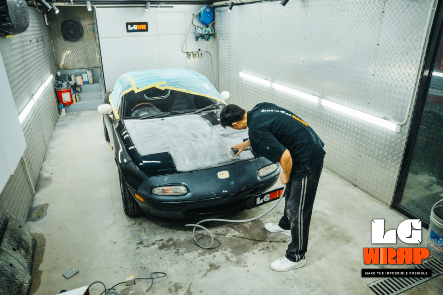 Mazda MX-5 NA undergoing extensive front-end sanding repair in the workshop