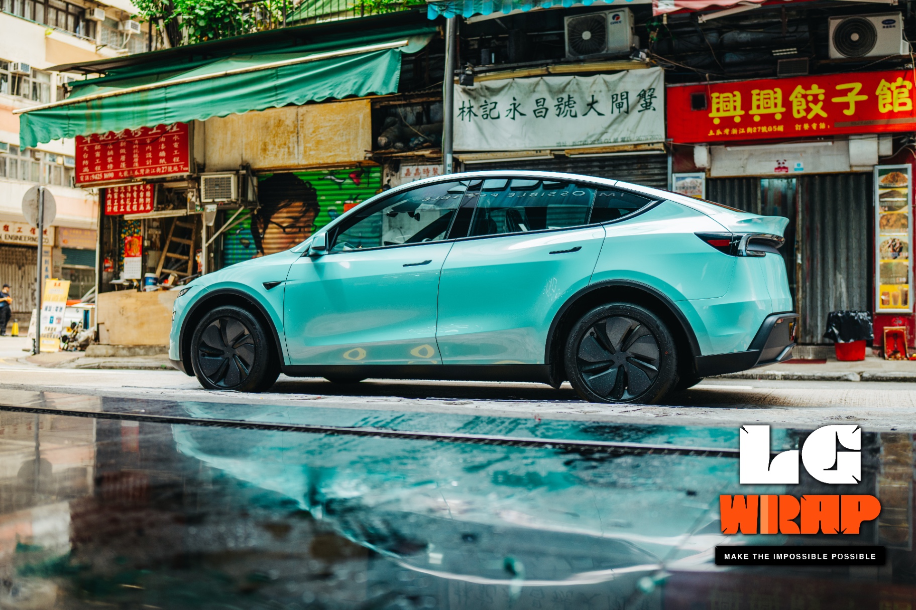 Side street view of a Tesla Model Y after a full-body light blue-green Colour PPF wrap