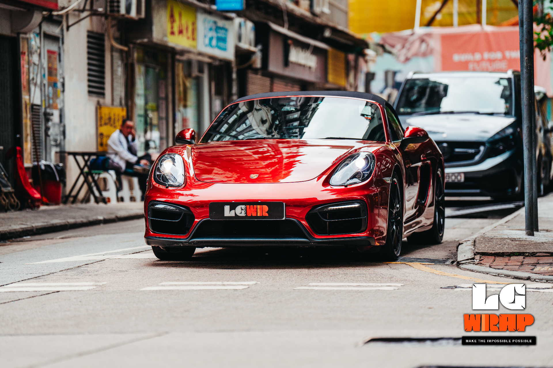 Front street view of a red Porsche sports car, showing the complete streamlined look and mirror-like gloss after full-body wrap